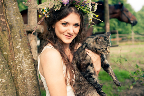 Pretty woman in flower wreath with cat - Foto, Imagen