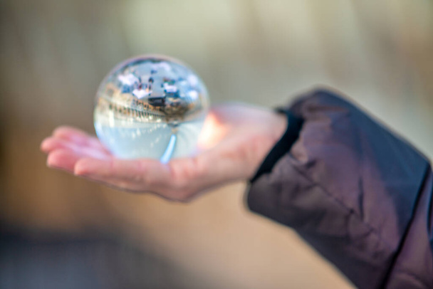 Bola de cristal na mão de uma mulher que mostra o interior do edifício moderno - Foto, Imagem