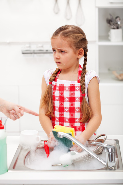 Sulking little girl doing the dishes - Фото, зображення