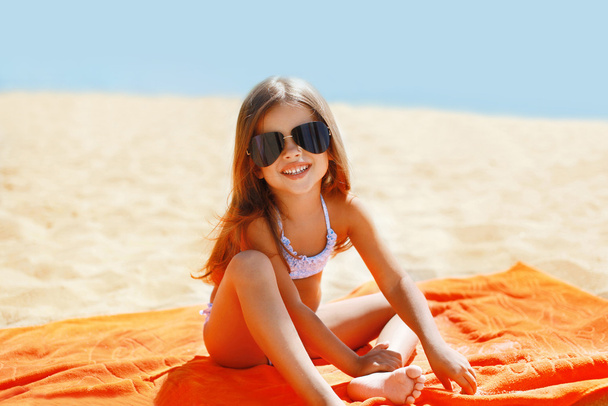 Child has a rest in the summer on the beach - Foto, Imagen