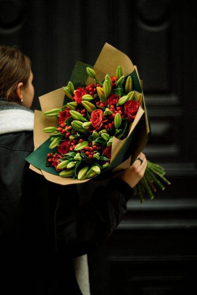 Bellissimo bouquet rosso e verde nelle mani delle ragazze - Foto, immagini