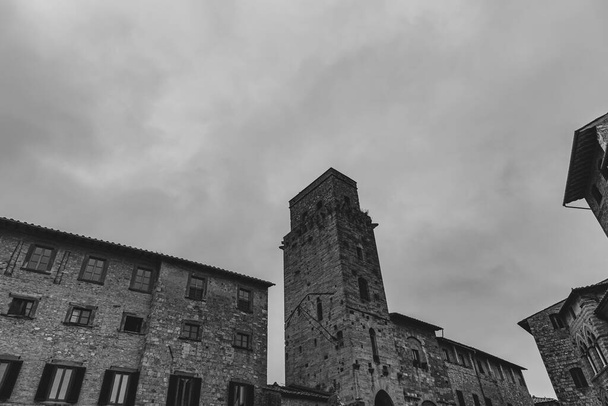 San Gimignano on kaupunki Toscanassa. 1200-luvun muurien ympäröimä sen historiallisen keskustan keskipiste on Piazza della Cisterna. Keskiaikaisten tornien taivaanrannassa seisoo Torre Grossa kivessä. - Valokuva, kuva