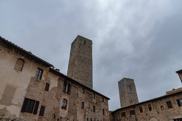 San Gimignano ist eine Stadt in der Toskana. Das Herzstück der von Mauern aus dem 13. Jahrhundert umgebenen Altstadt ist die Piazza della Cisterna. In der Skyline der mittelalterlichen Türme steht der Torre Grossa aus Stein. - Foto, Bild