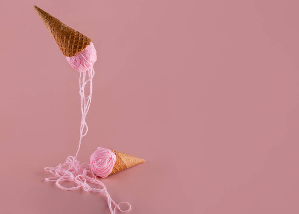 ピンクの背景にアイスクリーム趣味の概念の代わりにピンクの糸で2つのワッフルコーン - 写真・画像