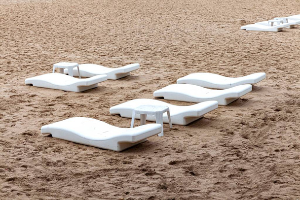 Salgından kurtulmak için otelin plajında boş güneş yatakları. - Fotoğraf, Görsel