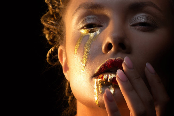 Gold on the skin, face art and creative makeup, gold as tears and blood - Photo, image