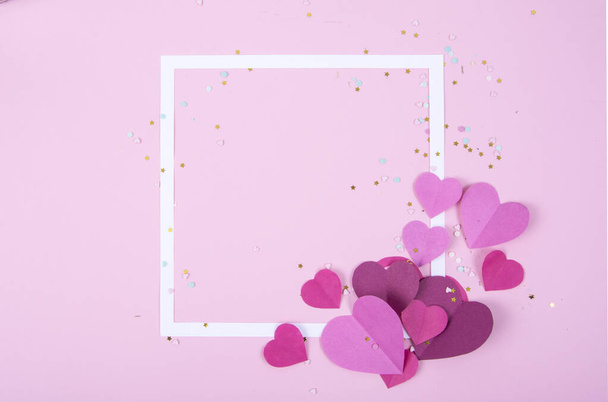 Abstrakter Hintergrund mit Papierherzen und leerem weißen Rahmen zum Valentinstag. Pink Love and Feeling Background für Poster, Banner, Post, Karten. Ansicht von oben - Foto, Bild