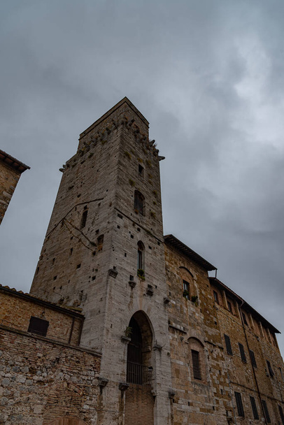 San Gimignano on kaupunki Toscanassa. 1200-luvun muurien ympäröimä sen historiallisen keskustan keskipiste on Piazza della Cisterna. Keskiaikaisten tornien taivaanrannassa seisoo Torre Grossa kivessä. - Valokuva, kuva