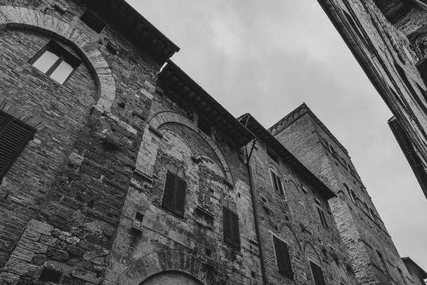 Сан-Джиміньяно - місто в Тоскані. Оточений стінами XIII століття, центральним елементом його історичного центру є П'яцца делла Цістерна. На горизонті середньовічних веж стоїть Торре - Гросса на камені.. - Фото, зображення