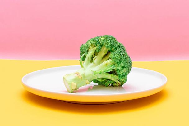 Fresh and Raw Broccoli on White Dish. Uncooked Green Cabbage - Zdjęcie, obraz
