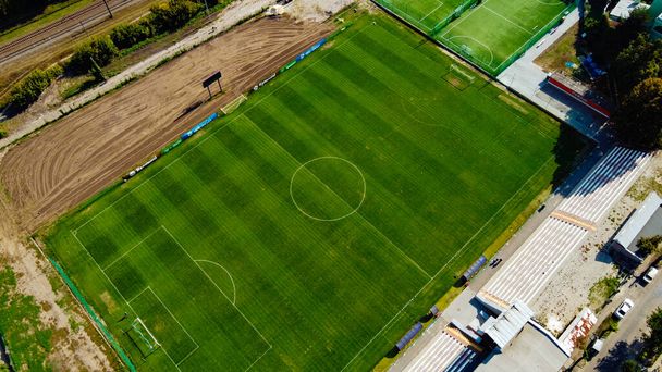 Aerial view of an empty soccer football field in town with railway. Sport travel concept - Zdjęcie, obraz