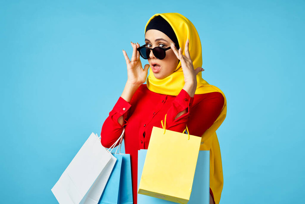 muslim woman in hijab shopping entertainment blue background - Фото, зображення