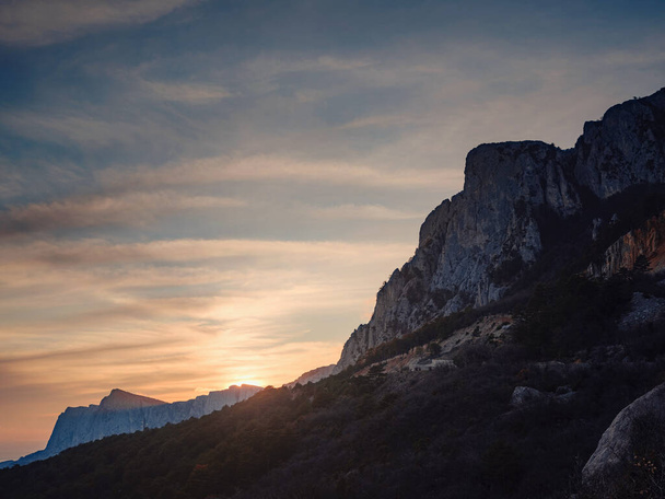 beautiful sunset in mountains, silhouettes of rocks and trees. Idea and concept of discovery, adventure, freedom of movement and relaxation - Fotoğraf, Görsel
