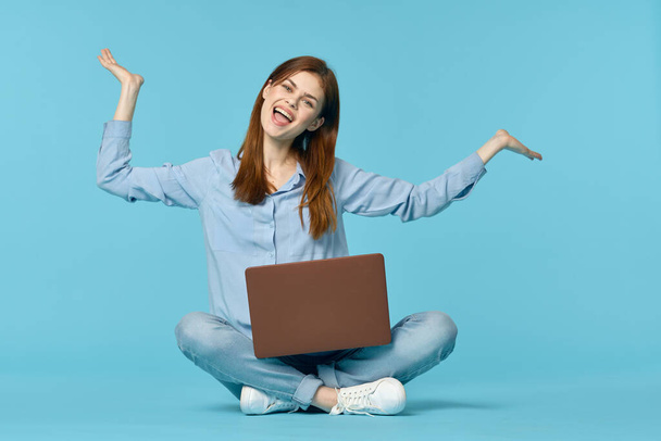 woman with laptop learning internet online education blue background - Foto, afbeelding