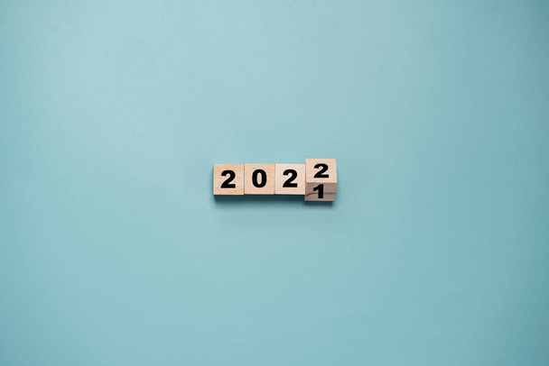 2021年から2022年まで青を背景に木製のキューブブロックが反転し、陽気なクリスマスと幸せな新年と3Dレンダリングのコンセプトの準備. - 写真・画像