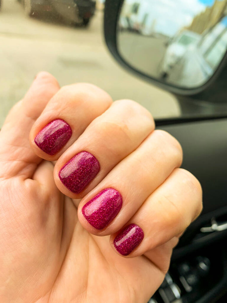 Female hand with bright gel polish in car - Photo, Image
