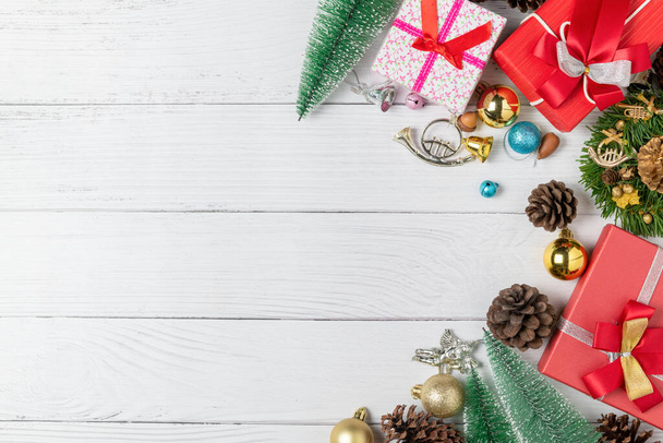 Vánoční pozadí s červeným dárkem a jedle a dekor na bílém dřevě pozadí. Horní pohled s mezerou pro kopírování - Fotografie, Obrázek