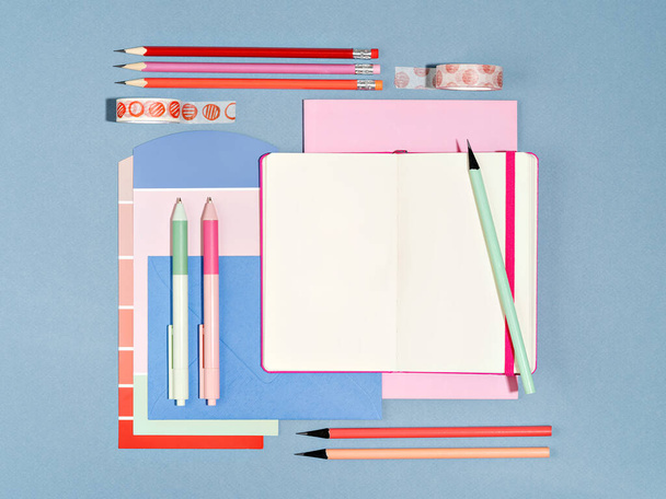 Top view of designers workplace with colour swatch and office supplies. Desk of artist or creative occupied freelance girl. Mock up of planner, to do list, sketchbook. Work from home concept. - Foto, immagini