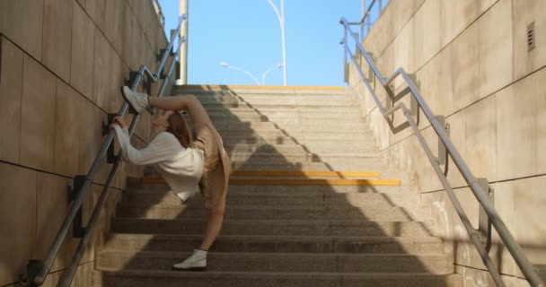 Genç dansçı kadın merdivenlerde ters bacak sallıyor. 4k 60 fps Prores karargahı. - Video, Çekim