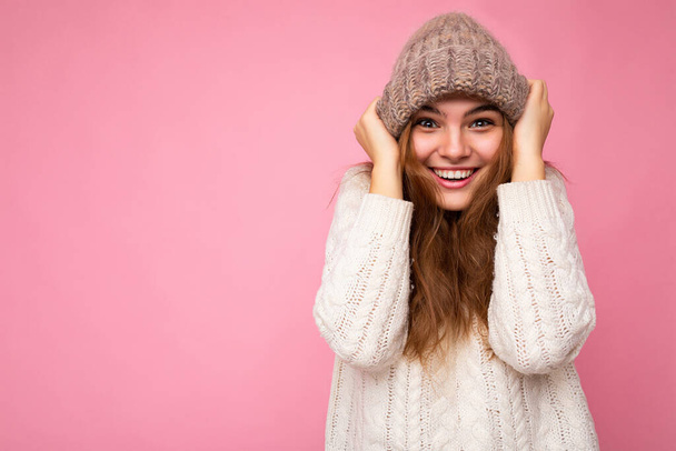 Ελκυστική χαμογελαστή ευτυχισμένη νεαρή μελαχρινή γυναίκα στέκεται απομονωμένη πάνω από πολύχρωμο φόντο τοίχο φορώντας καθημερινά κομψό ντύσιμο δείχνει τα συναισθήματα του προσώπου κοιτάζοντας κάμερα - Φωτογραφία, εικόνα