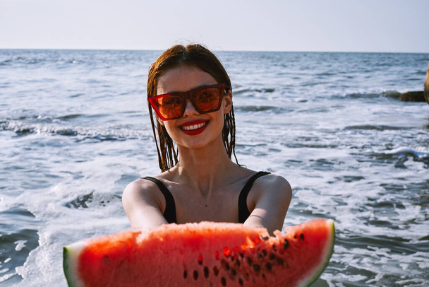 pretty woman in a black swimsuit with a watermelon in her hands summer Ocean - Fotoğraf, Görsel