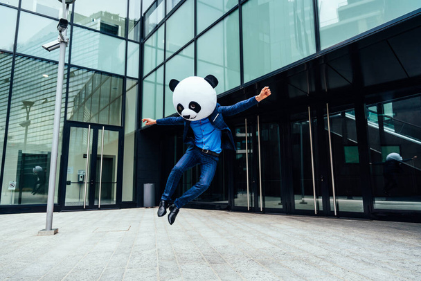 Storytelling image of a business man wearing a giant panda head - Фото, изображение