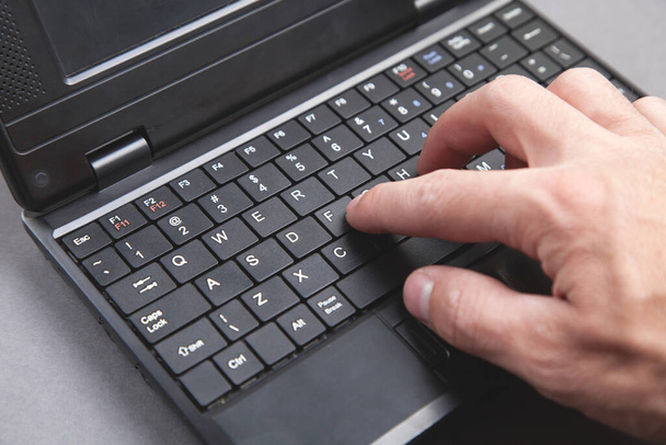 Male hand typing on computer keyboard. - Фото, изображение