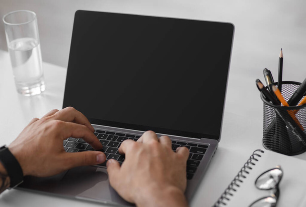Evropský dospělý muž pracující na notebooku s prázdnou obrazovkou, na pracovišti - Fotografie, Obrázek