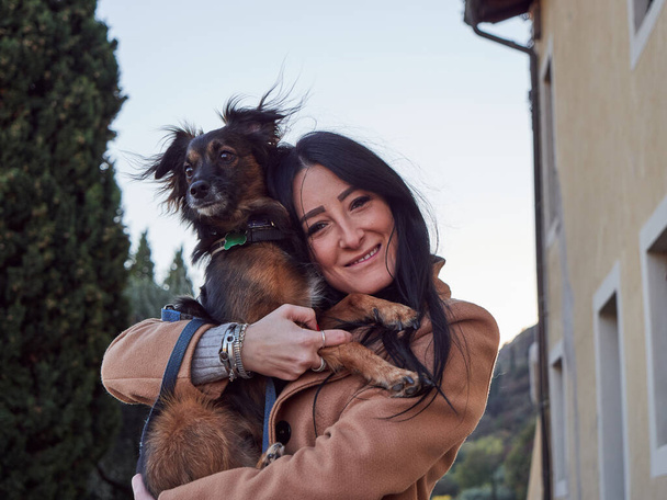 Brunette woman play with little dog - Фото, изображение