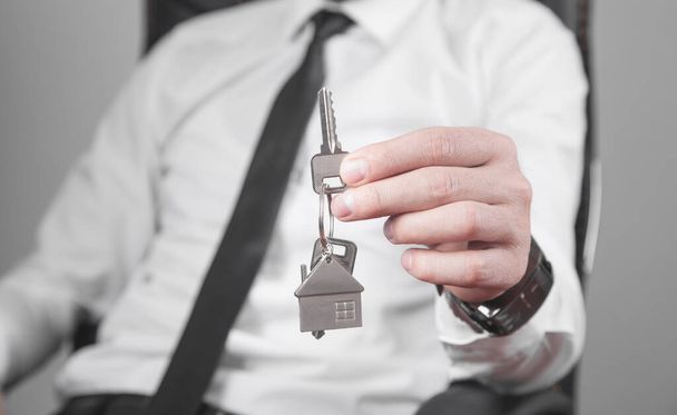 Агент по недвижимости держит ключи от дома. - Фото, изображение