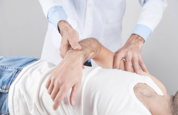 Caucasian doctor massaging patient hand. - Fotó, kép