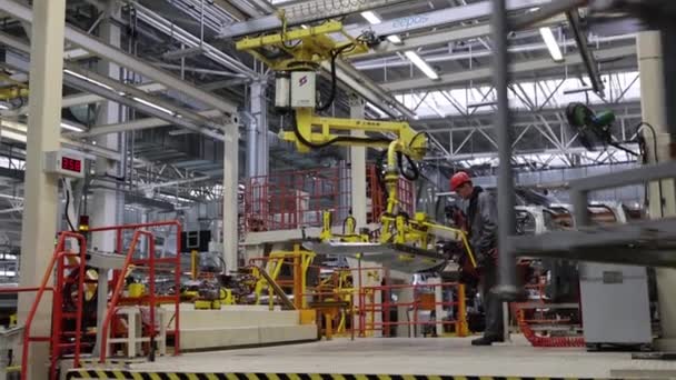 Borissow, Weißrussland - 29. OKTOBER 2021: Arbeiter in einer modernen Autofabrik, Aluminiumtüren, automatisierte Produktion - Filmmaterial, Video