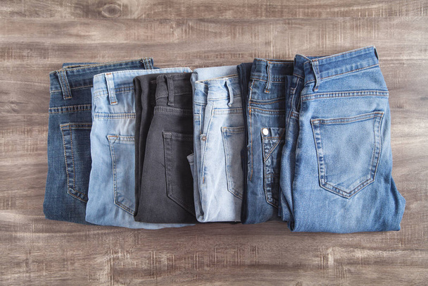 Jeans on the brown wooden background. - 写真・画像