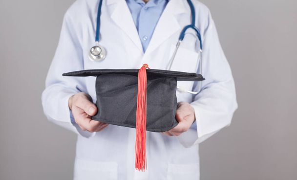 Caucasian doctor holding graduation hat. Medical education - Foto, Imagem