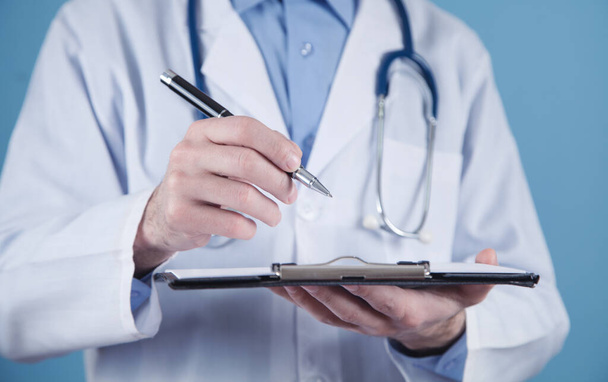 Medical doctor holding pen and clipboard. - Photo, Image