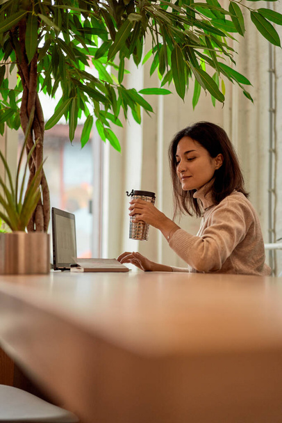 Female freelancer drinking coffee during work - Фото, зображення
