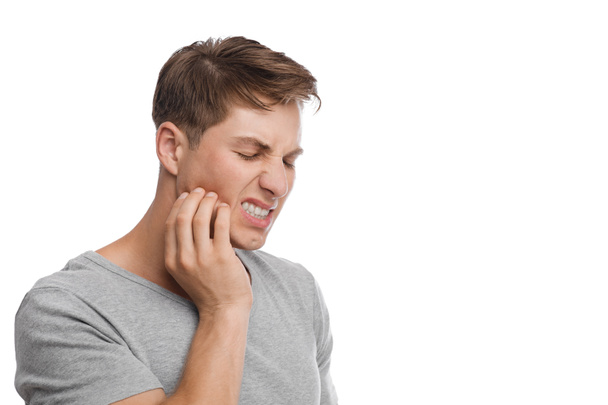 Désespéré millénariste caucasien attrayant mâle presse sa main à la joue et souffre de maux de dents - Photo, image