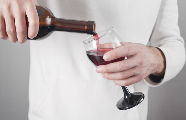 Man rode wijn in een glas gieten. - Foto, afbeelding