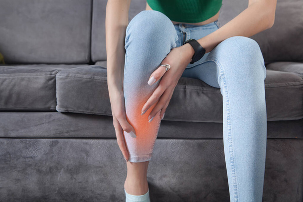 Woman suffering from leg pain at home. - Valokuva, kuva