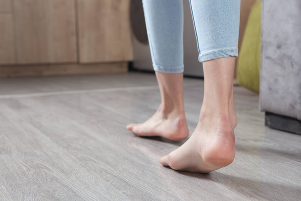 Weibliche Füße laufen zu Hause auf dem Boden. - Foto, Bild