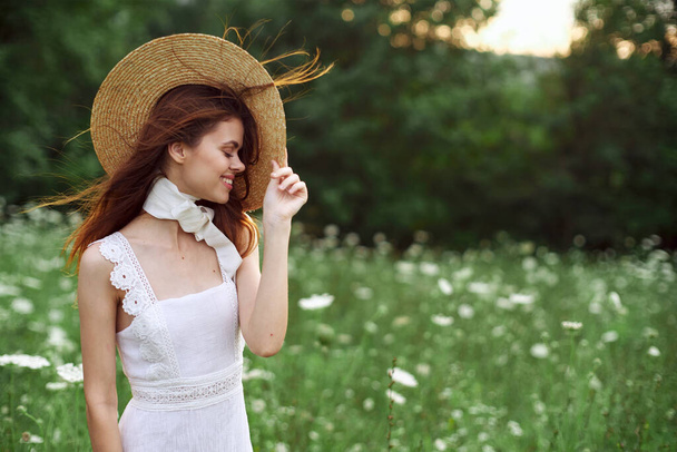 beautiful woman in a hat in a field with flowers walk - Valokuva, kuva