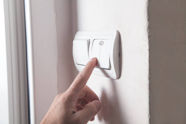 Hand turning off on light switch. - Photo, Image