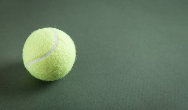 Теннисный мяч на зеленом фоне. Пространство для текста - Фото, изображение