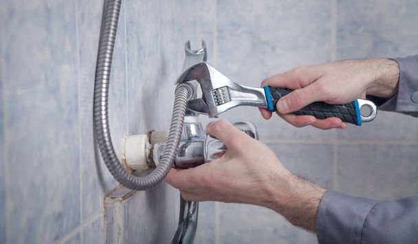Man repair and fixing shower faucet in bathroom. - 写真・画像