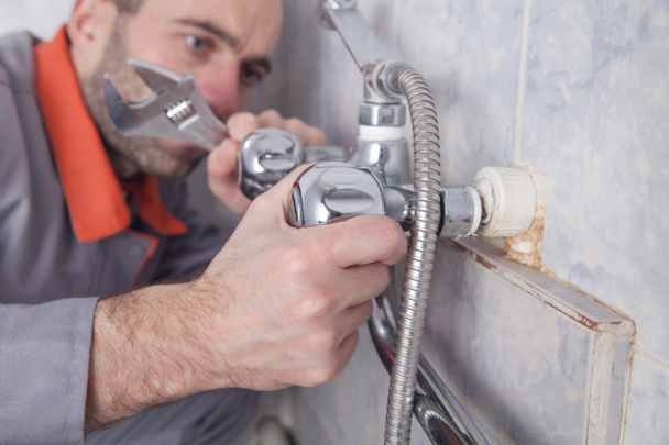 Человек ремонт и ремонт душа кран в ванной комнате. - Фото, изображение