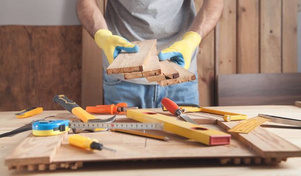Carpenter holding wooden planks. Woodworking industry - Fotó, kép
