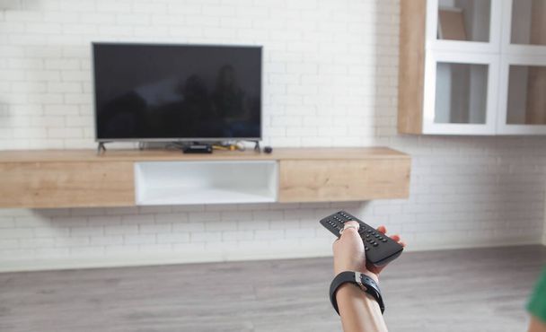 Woman using tv remote controller. Watching tv  - Photo, Image