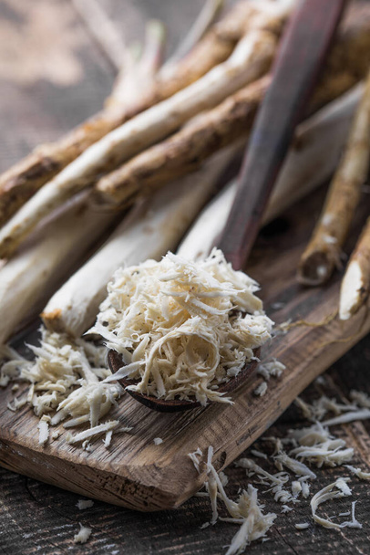 Fresh organic horseradish or Horse-radish root on wooden cutting board. - Photo, Image