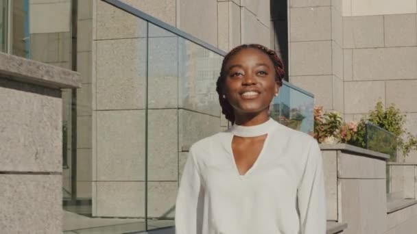 Pohybující se natáčení úspěšný šťastný bezstarostný afro americká dívka radostný africký obchod žena student dáma šéf turista chůze moderní město ulice venku chůze jít dovnitř v létě den - Záběry, video