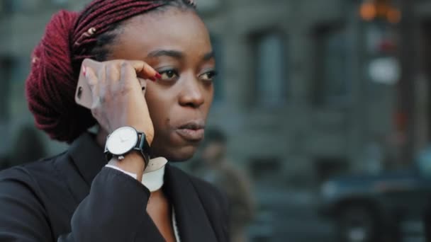 Sérieux afro-américaine fille en colère africaine femme d'affaires se sentent furieux colère parler querelle téléphone mobile négociation problèmes désaccord répondre à l'appel pas de marche dans la ville parler smartphone sur la rue - Séquence, vidéo